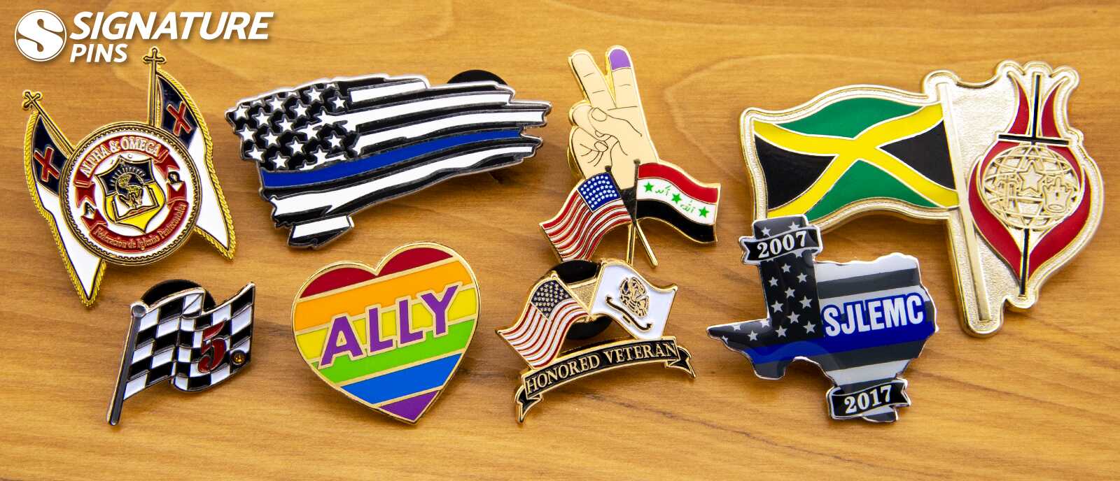 Custom flag pins including thin blue line American flag, LGBTQ ally heart, Jamaica flag, checkered racing flag, and Honored Veteran pins