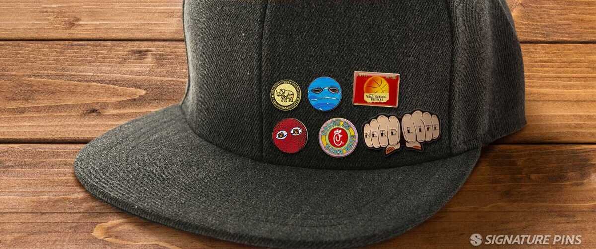 Gray snapback cap with colorful enamel pins including basketball and Nerd Life fist designs