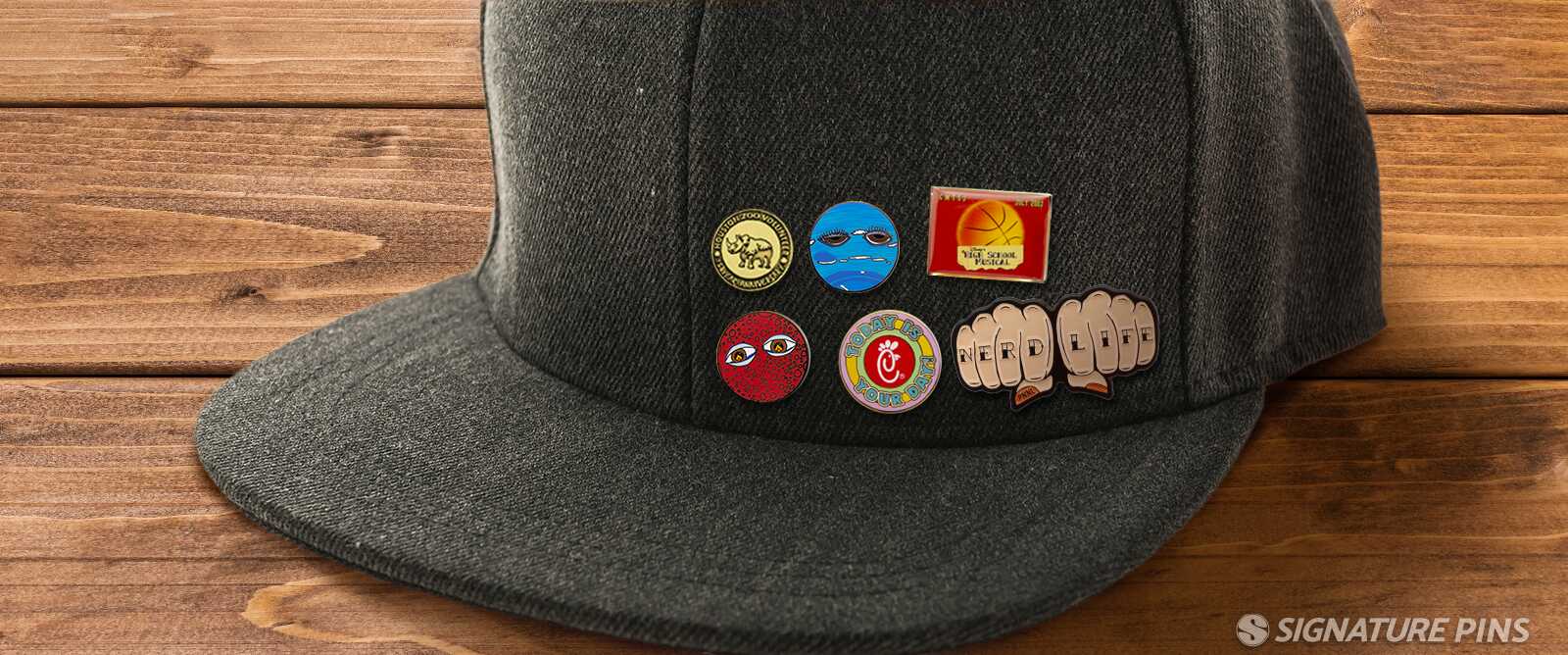 Gray snapback cap with colorful enamel pins including basketball and Nerd Life fist designs