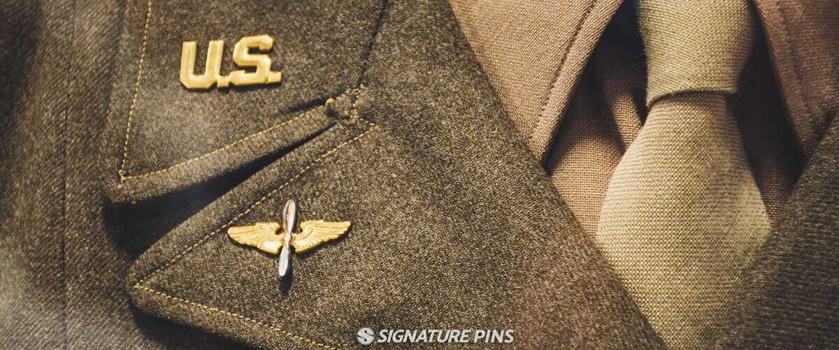 Close-up of vintage military uniform with gold U.S. collar pin and Army Air Corps winged propeller pin on olive drab jacket
