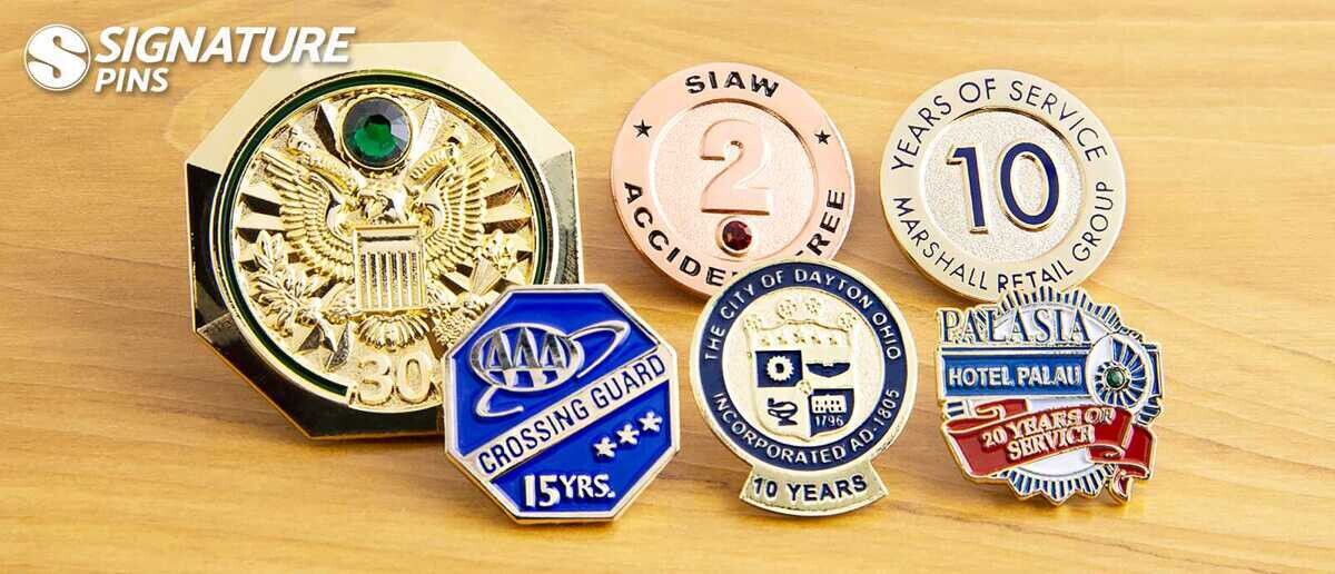 Various years of service pins including gold 30-year eagle pin with gemstone, AAA Crossing Guard 15 years, City of Dayton 10 years, and Palasia Hotel Palau 20 years